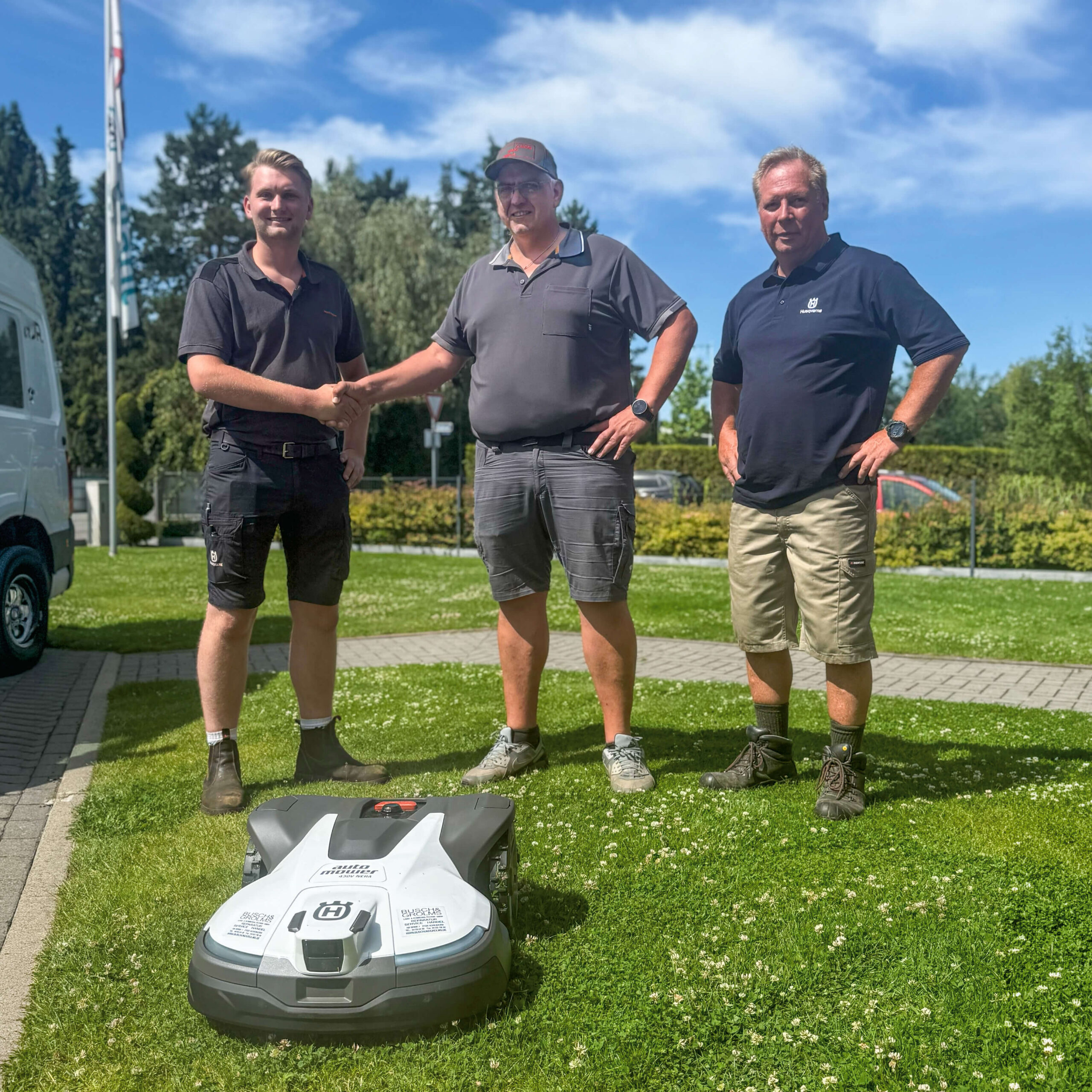 Marvin Skrupke, Maik Clausen und Sven Haberland bei der Übergabe des Husqvarna Automower® 430V auf dem Firmengelände der Clausen Haustechnik GmbH.