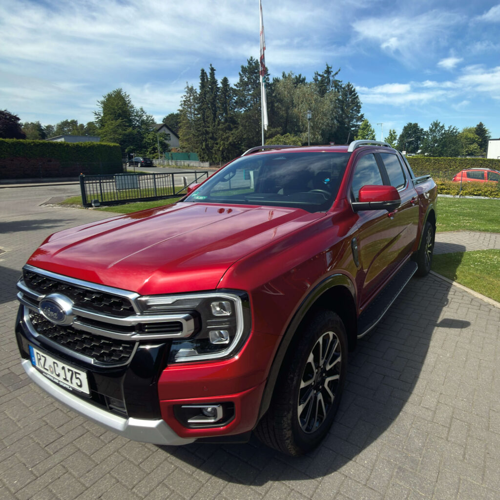 Ein roter Ford Ranger von Clausen Haustechnik steht auf dem Firmengelände. Das Fahrzeug ist für den Transport schwerer Anhänger und Baustelleneinsätze ausgestattet.