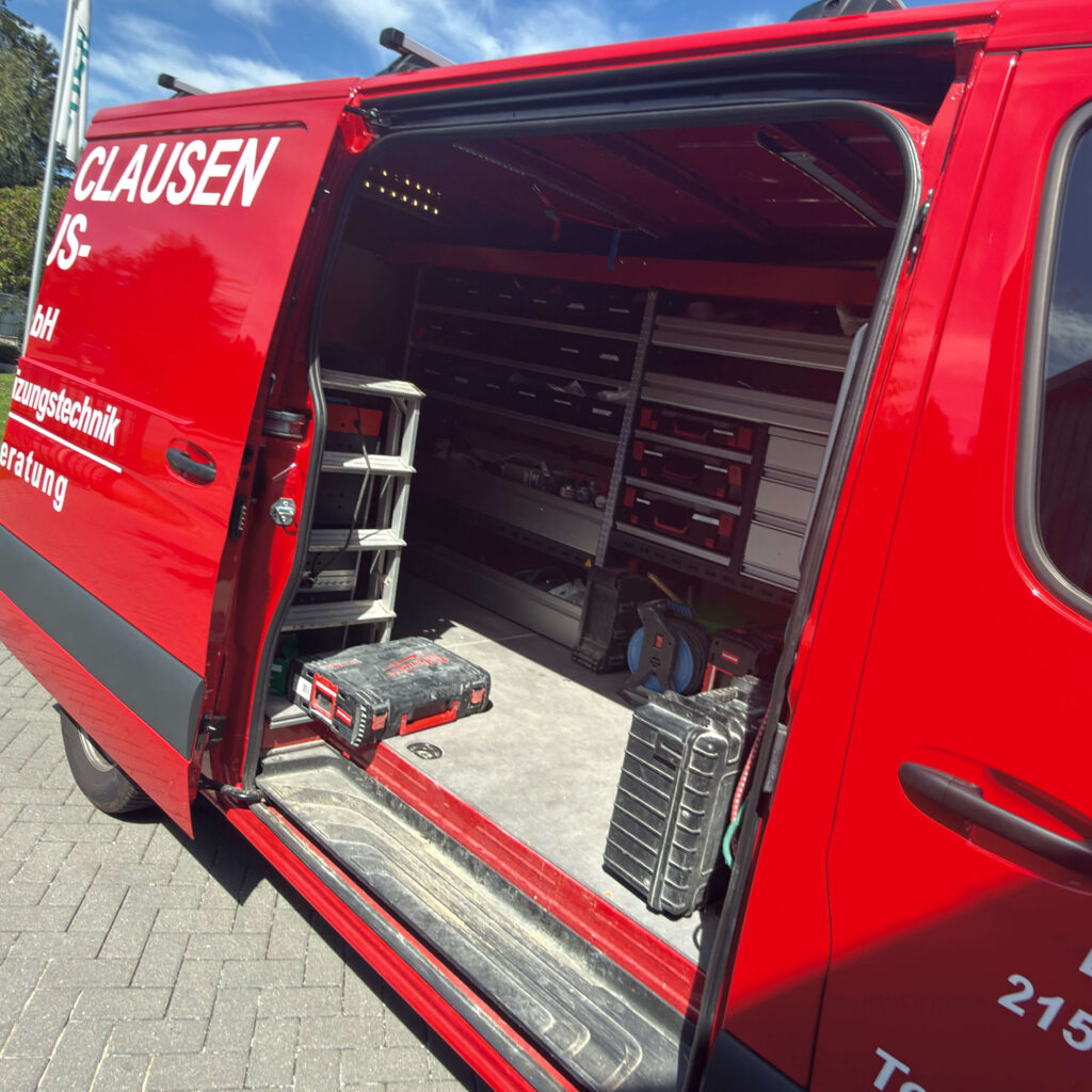 Der geöffnete Laderaum eines Mercedes Transporters von Clausen Haustechnik zeigt ein übersichtlich eingerichtetes Würth Regalsystem mit Werkzeugen und Arbeitsmaterial.