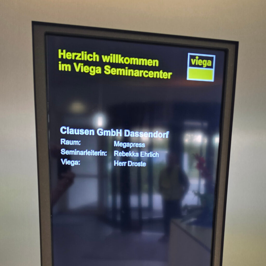 Willkommensbildschirm im Viega Seminarcenter zur SHK-Fachschulung von Clausen Haustechnik im Rahmen des Betriebsausflugs 2026.